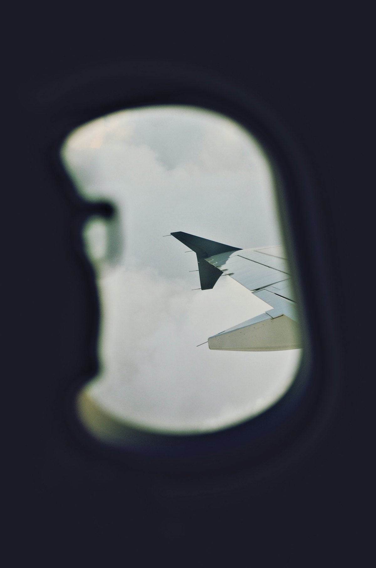 A view of clouds and a wing from an aircraft window