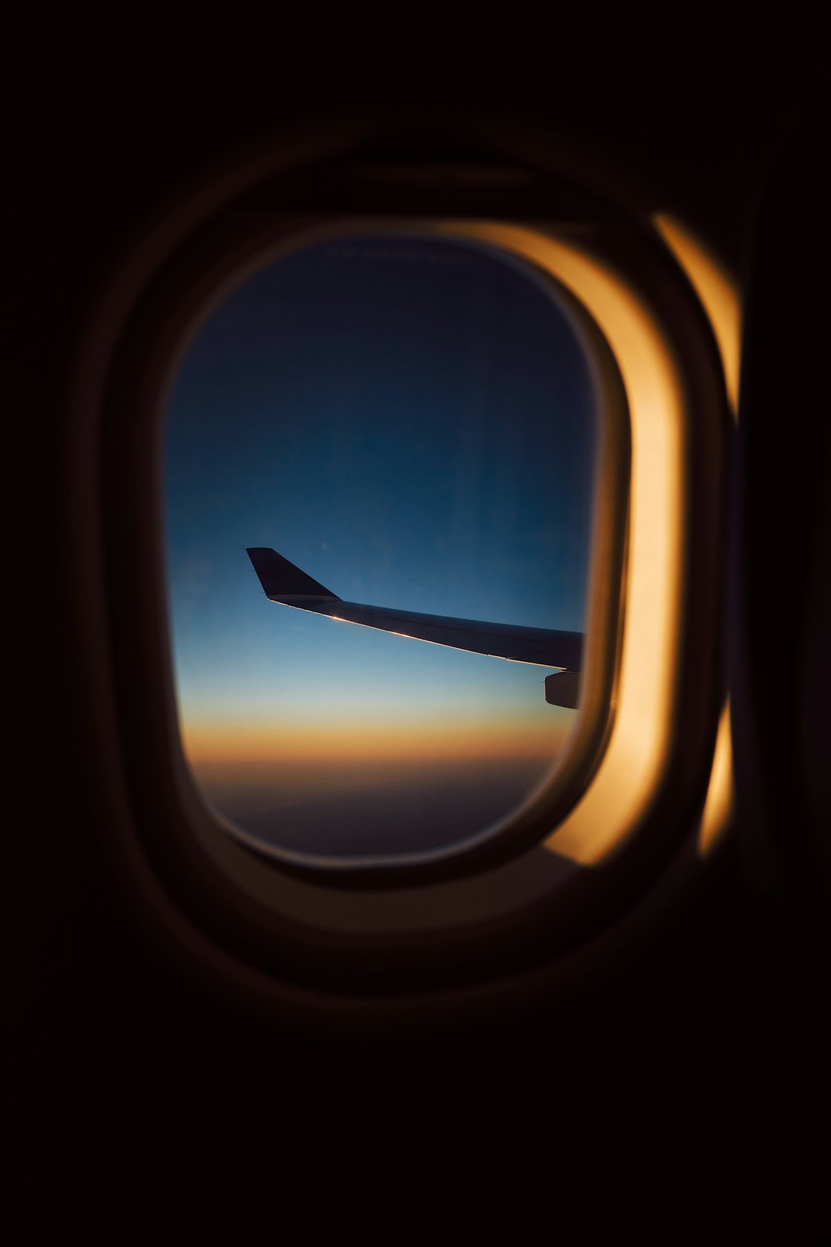 An aircraft wing seen from a window at sunset