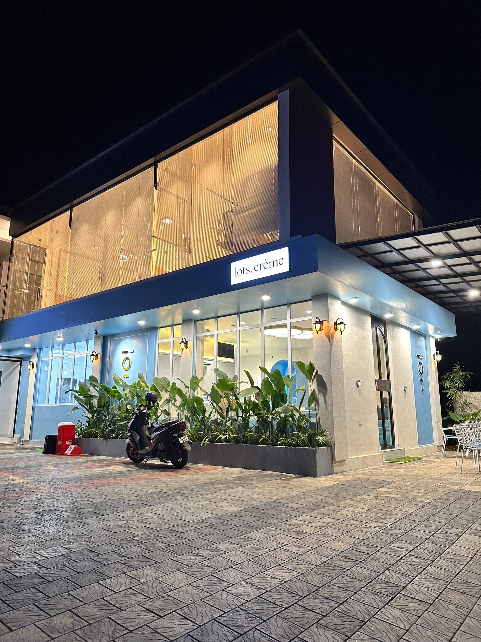 The Lots. Crème corner building in Manjeri, lit at night