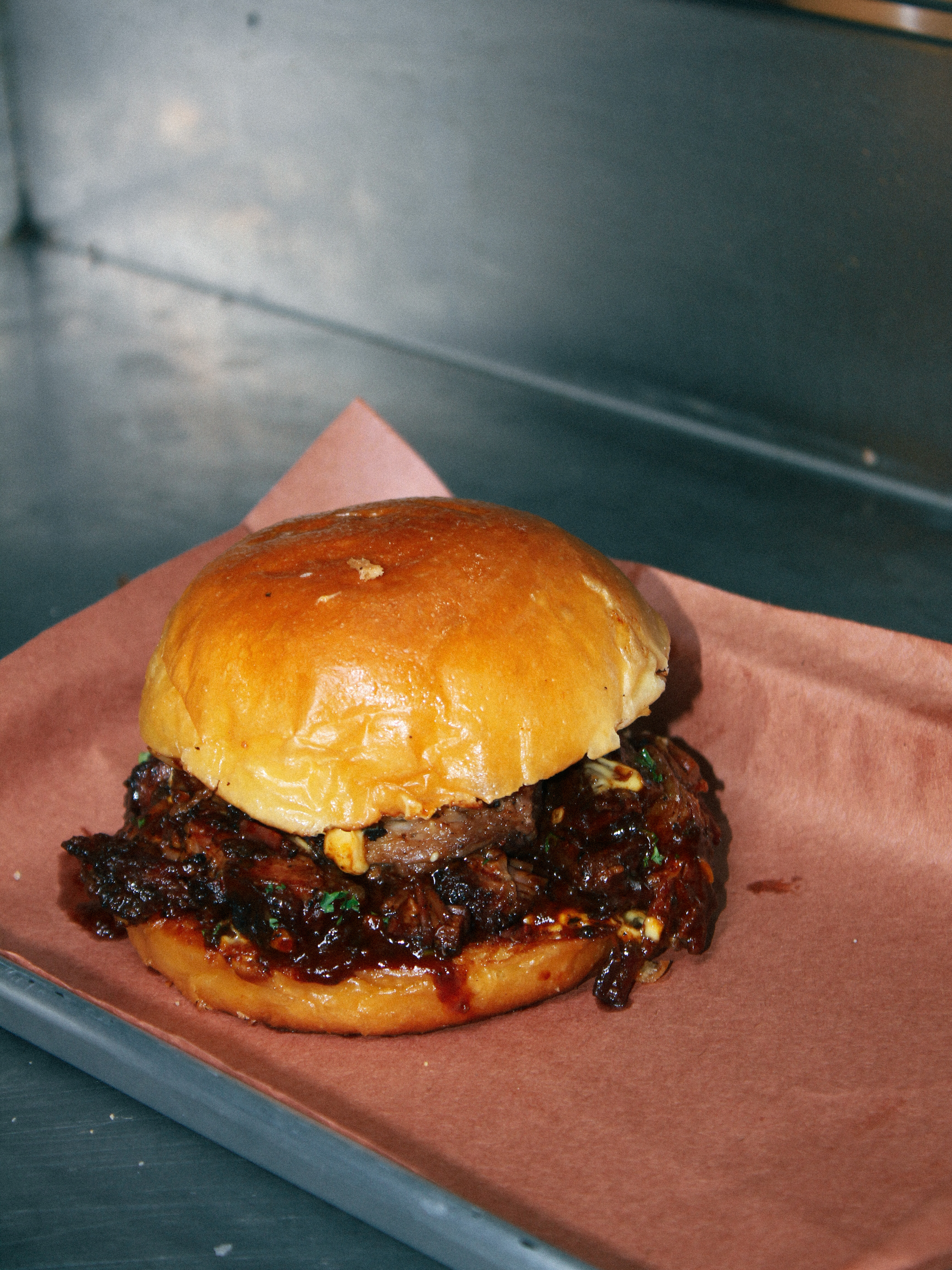 Brisket bun with sauced smoked beef on brioche