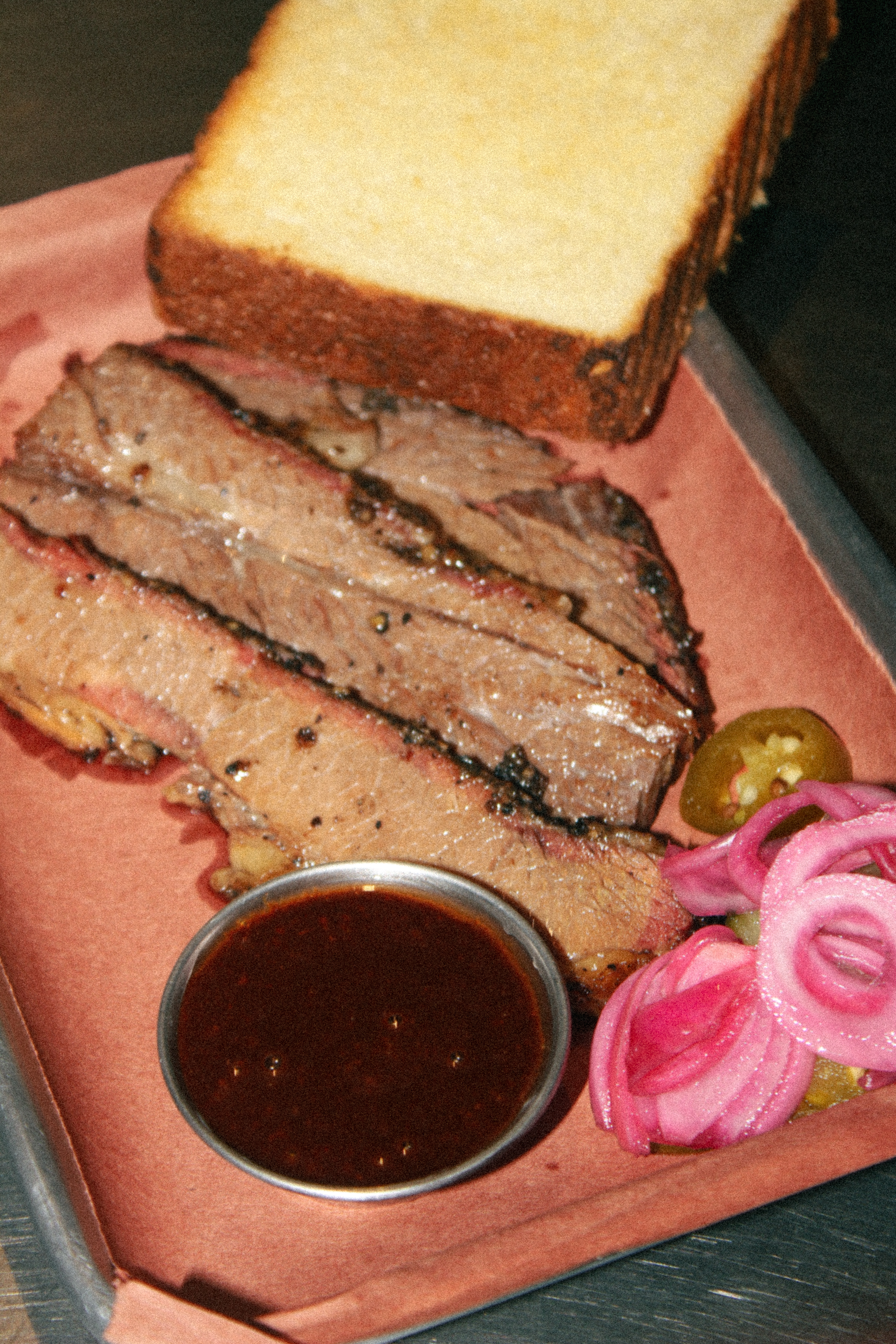 Smoked brisket platter with Texas toast, sauce, and pickled onions