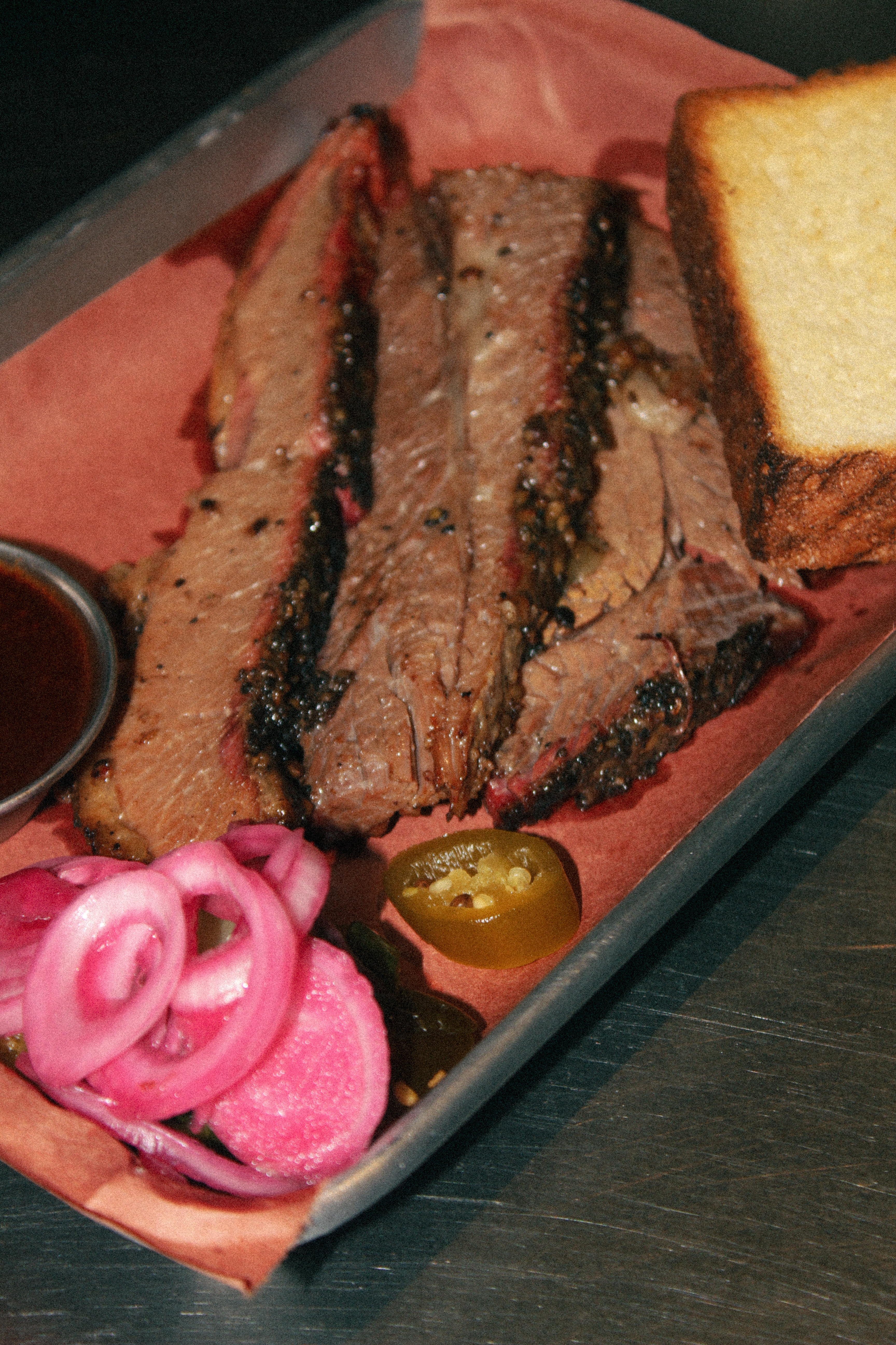 Sliced smoked brisket with toast and pickled onions